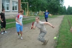 Cadet Hoffman takes off during the relay race, between the Cadets and students at Ariogalos Gimnazija, while the national 100 meter sprint record setter in Lithuania (left) reaches for his team's baton.